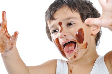 Little cute kid with chocolate on face and handsの写真素材