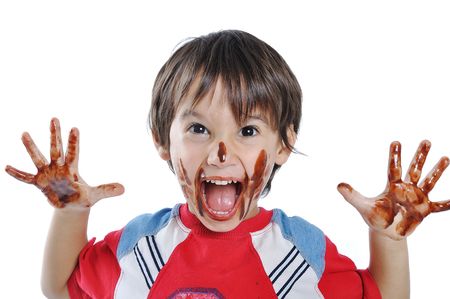 Little cute kid with chocolate on face and handsの写真素材