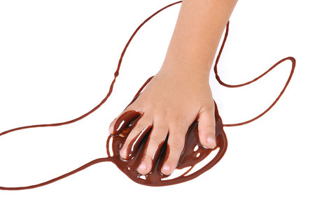 Kid's hand on liquid chocolateの写真素材