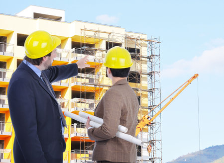  Two young engineers with blueprints 