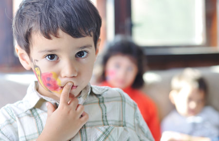 Cute kid with paints in the room