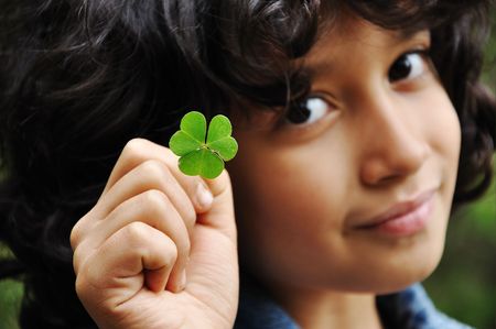 Little cute girl holding plant in natural shape of heartの写真素材