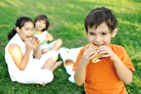 Small group of children in nature eating snacks together, sandwiches, breadの写真素材