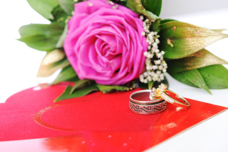 Love rose, for lover, on white with affiance (marriage) rings and red heart card