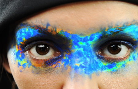 Portrait of the beautiful young girl in bright multi-coloured maskの写真素材