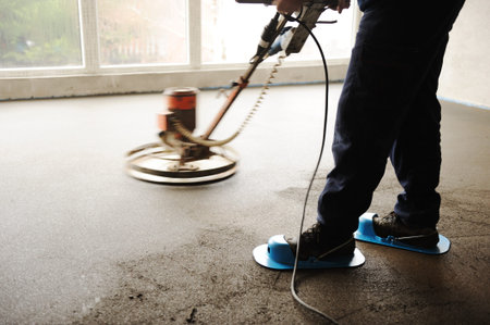 Equating and leveling fresh cement for the floor, by one workerの写真素材