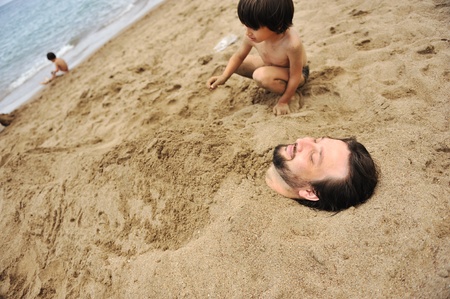 Real happiness, playing on beach: my dad under the sandの写真素材