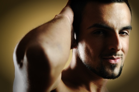 handsome  man posing against dark backgroundの写真素材