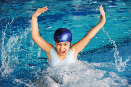 Activities on the pool, children swimming and playing, girl splashing waterの写真素材