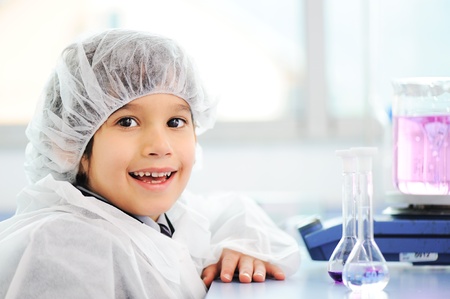 Smart cute little male child  experimenting with test tubes in real modern hospital labの写真素材