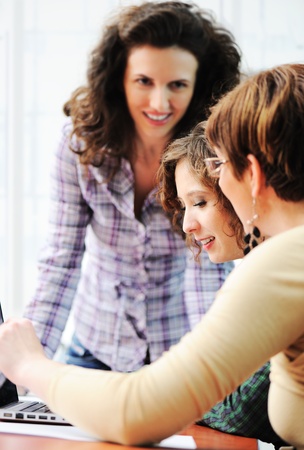 Group of young happy people looking into laptop working on itの写真素材