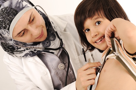 Muslim female doctor in hospital examining a little boyの写真素材