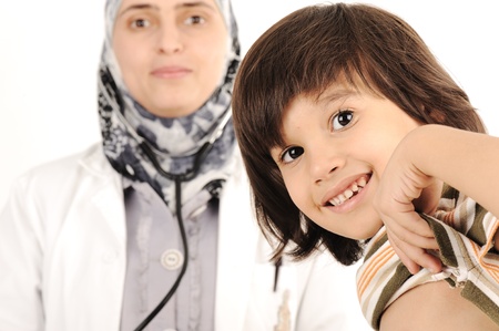 Muslim female doctor in hospital examining a little boyの写真素材