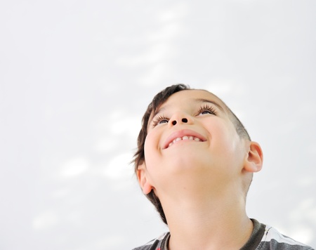 Cute little boy with funny hair and cheerful grimaceの写真素材