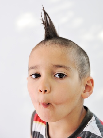 Cute little boy with funny hair and cheerful grimaceの写真素材