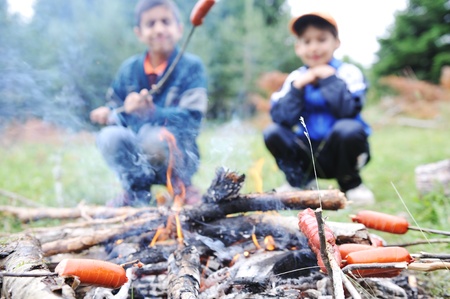 Barbecue in nature, group of people preparing sausages on fire (note: shallow dof)の写真素材