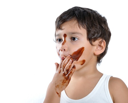 Kid with chocolate on his face and handsの写真素材