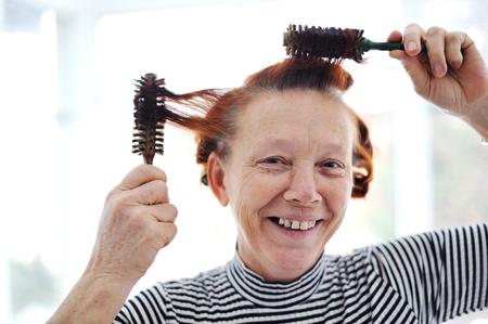 Senior lady hairdressing with many combsの写真素材