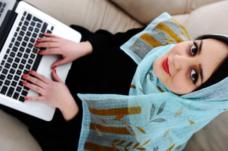 Young woman with laptop on couchの写真素材
