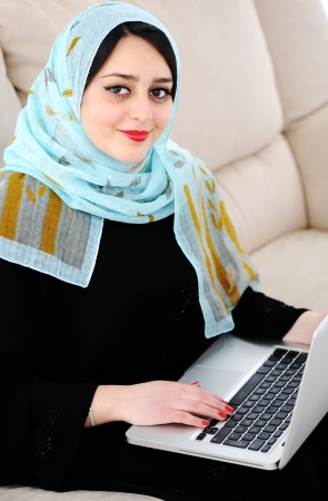Young woman with laptop on couchの写真素材