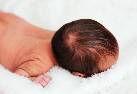 Newborn baby in hospital on bedの写真素材