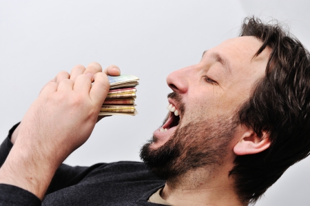 Man eating moneyの写真素材