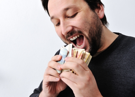 Man eating moneyの写真素材