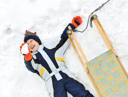 Kids sliding sledge in the snow