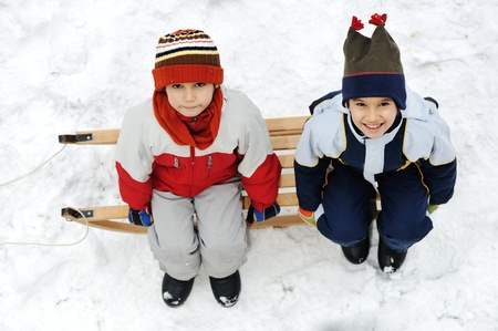 Kids sliding sledge in the snowの写真素材