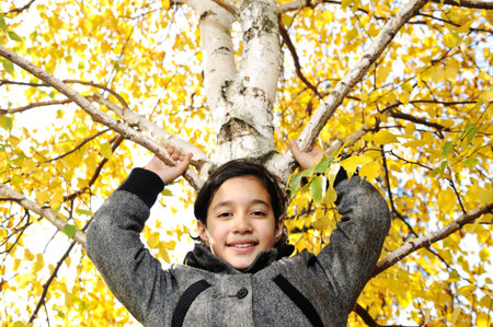 Happy kid and autumn leaves in a parkの写真素材