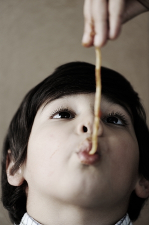 Kid eating spaghettiの写真素材