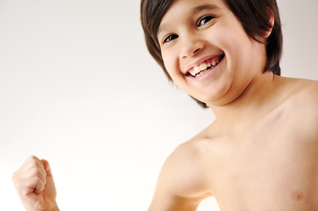 Child showing the muscles of his thin armsの写真素材