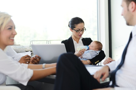 Business people taking care of baby in officeの写真素材