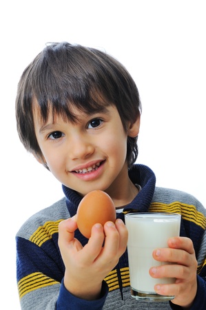 Cute little kid with glass of milk and eggの写真素材