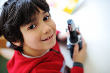 Cute little kid holding microscopeの写真素材