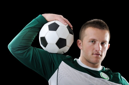 Proffessional footballer holding a ball on his shoulderの写真素材