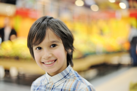 Handsome smiling boy in a grocery storeの写真素材