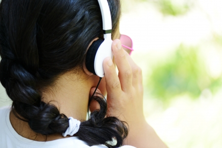 Beautiful teenage girl with sunglasses listening to music on headphones and enjoyingの写真素材
