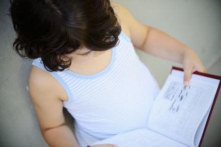 Little boy reading a book outdoorsの写真素材