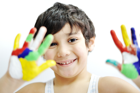 Little boy with hands painted in colorful paints ready for hand printsの写真素材