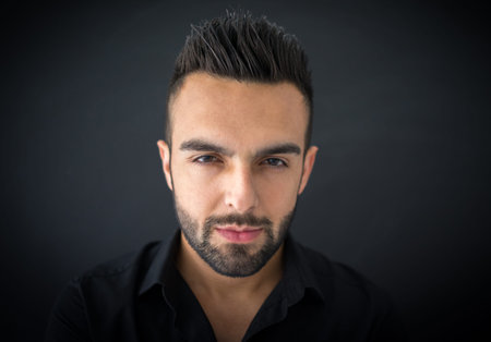 Portrait of a smart serious young man standing against blue の写真素材