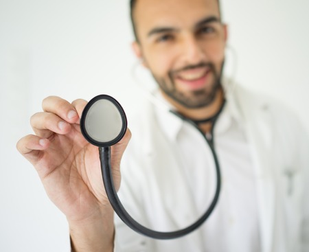 Handsome young doctor using stethoscopeの写真素材