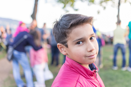Kid standing in crowd of peopleの写真素材