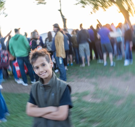 Kid standing in crowd of people (Note: Motion blur is real and not made in postproduction)の写真素材