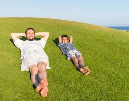 Happy summer vacation for kids on green meadow near seaの写真素材