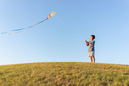Running with kite on summer holiday vacation, perfect meadow and sky on seasideの写真素材