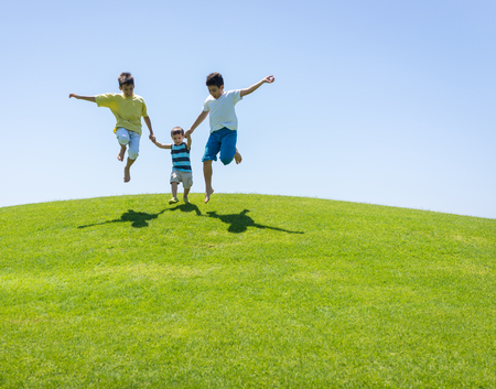 Happy summer vacation for kids on green meadow near seaの写真素材