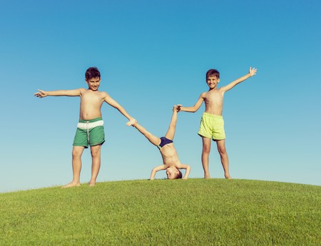Happy summer vacation for kids on green meadow near seaの写真素材