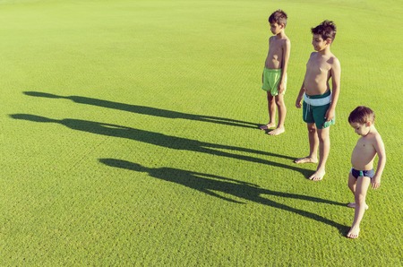 Happy summer vacation for kids on green meadow near seaの写真素材