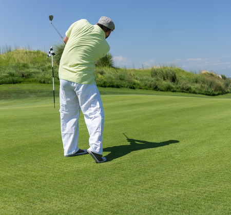 Man playing golf at clubの写真素材